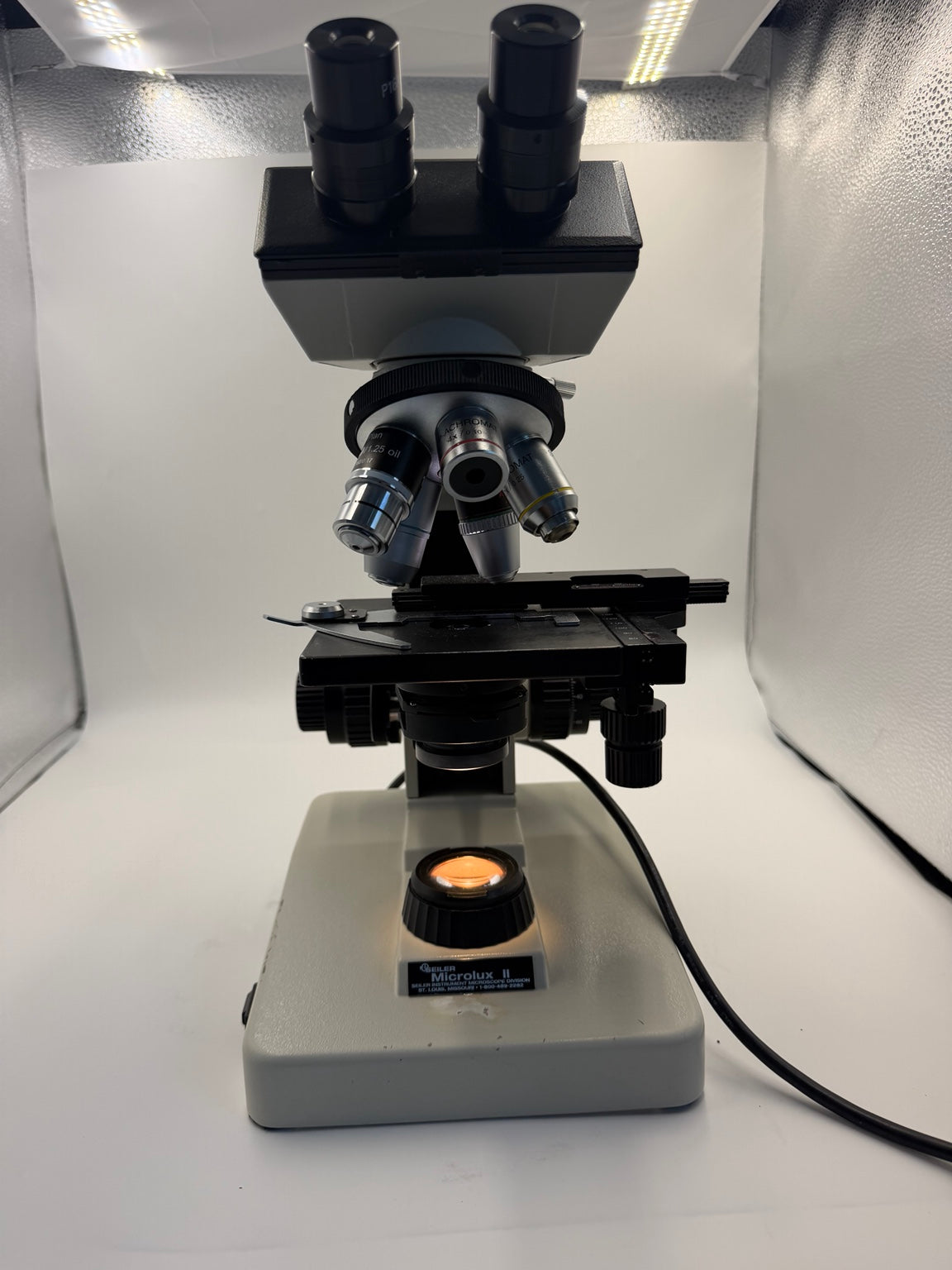 Seiler Microlux II binocular compound microscope front view with illumination working